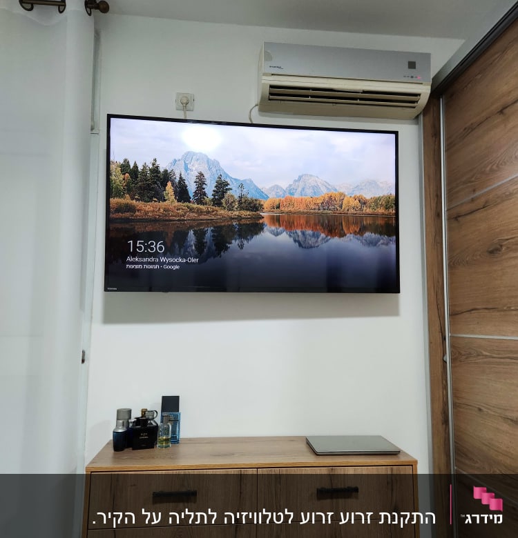 טלוויזיה תלויה על הקיר עם מזגן מעליה